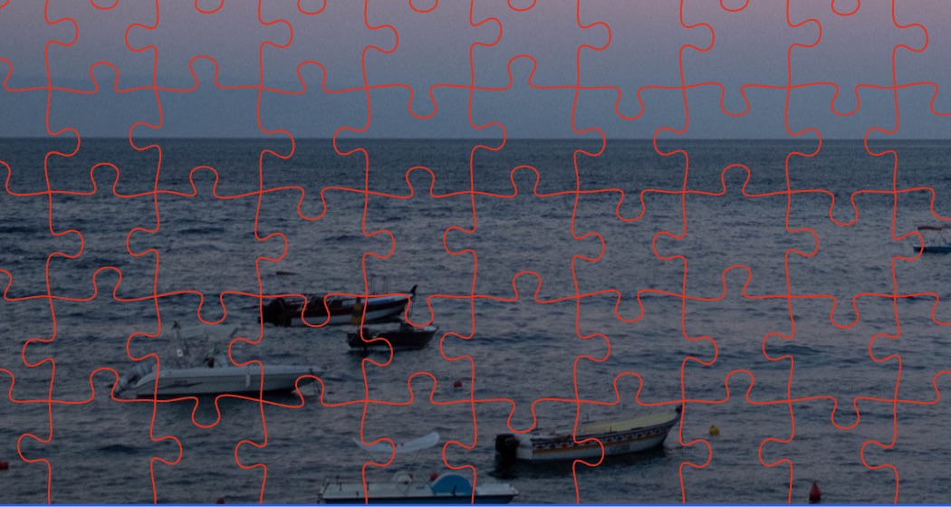 Close up of the proof: jigsaw pieces cut across boats on the water at dusk.